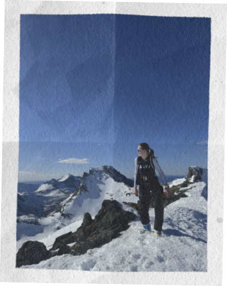 Isabel standing on a snowy mountain summit